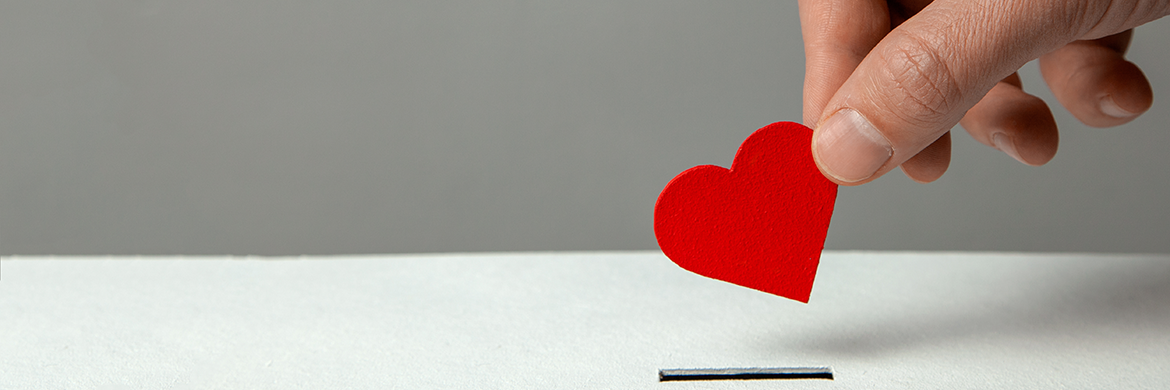 Person holding small red paper heart